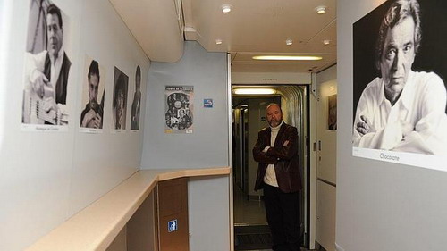 El fotógrafo Paco Sánchez, en el AVE junto a varios retratos, como el de El Chocolate, de su exposición. 